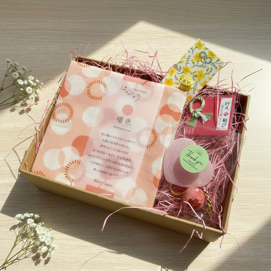 Japanese mystery gift box with pink akebono-iro furoshiki, temari ball and lucky charms, handpicked in Osaka Japan